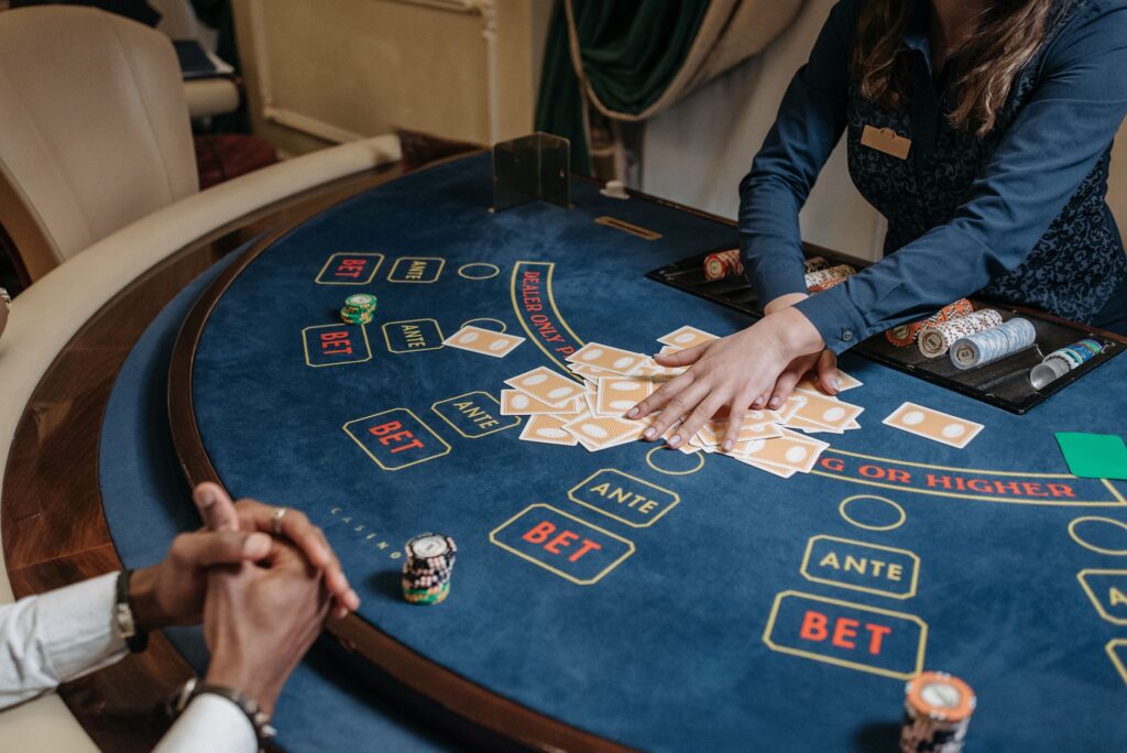 Mâinile unui dealer care amestecă un pachet de cărți deasupra unei mese de poker